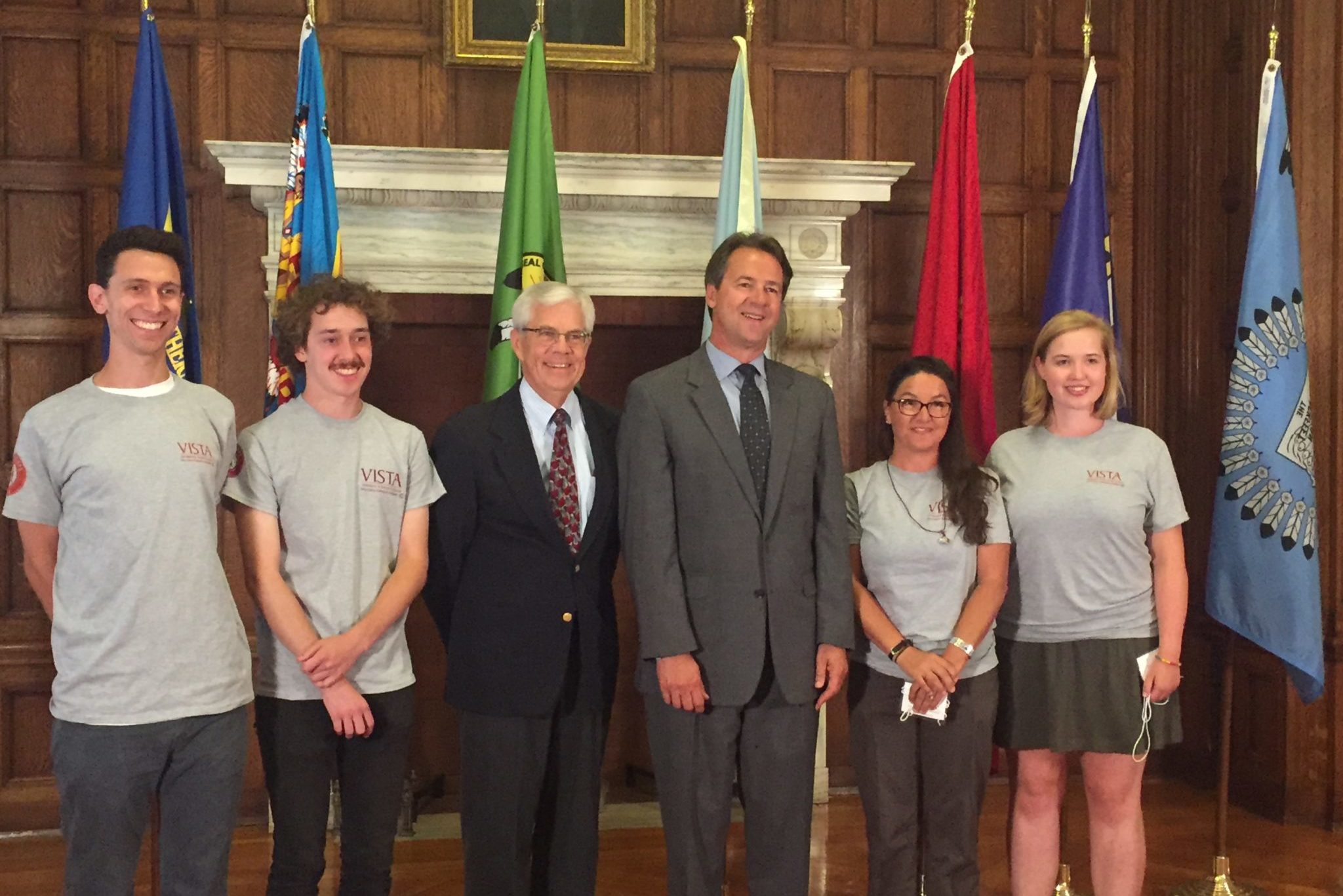 Former Governor of Montana Steve Bullock and Former Lieutenant Governor Mike Cooney posing with a group of AmeriCorps members in the Montana state capital building