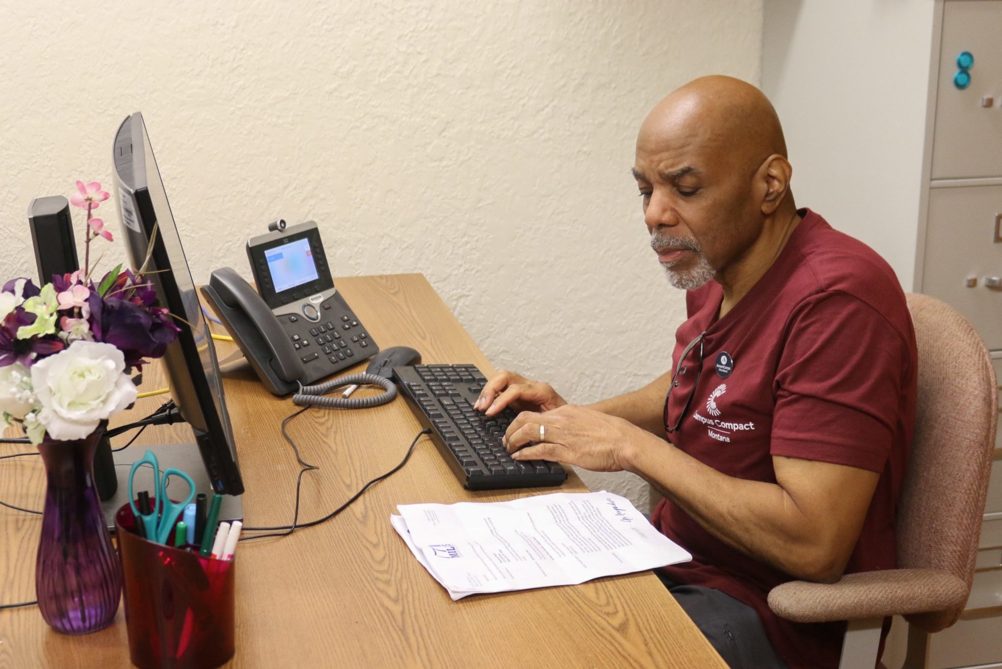 AmeriCorps member typing at a desk.