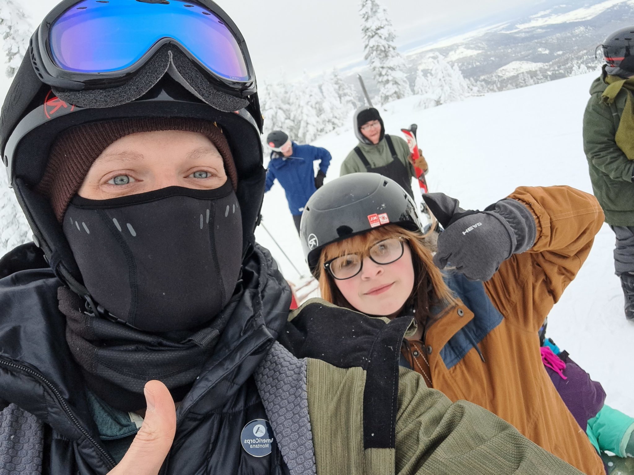 AmeriCorps member and student wearking ski gear outdoors in the snow.